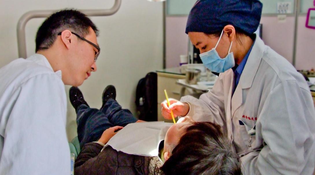 Projects Abroad Medical intern examines a young boys mouth in a dentist chair during a Medicine internship in China. Medical interns examine a young boys mouth at a Dental workshop during their Medicine placement in China.